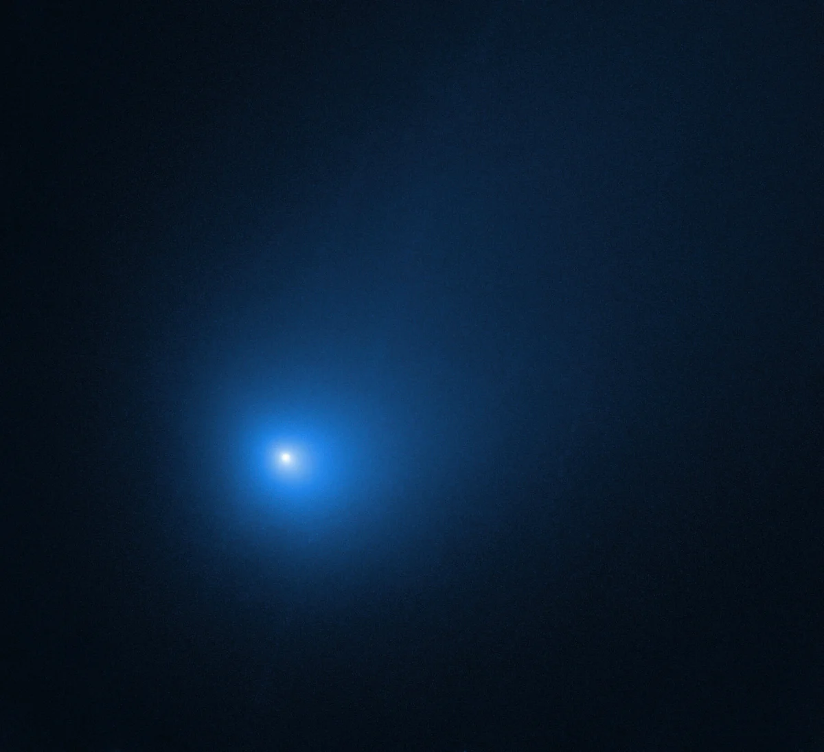 A Hubble image of a comet with a bright head and a soft tail against black space