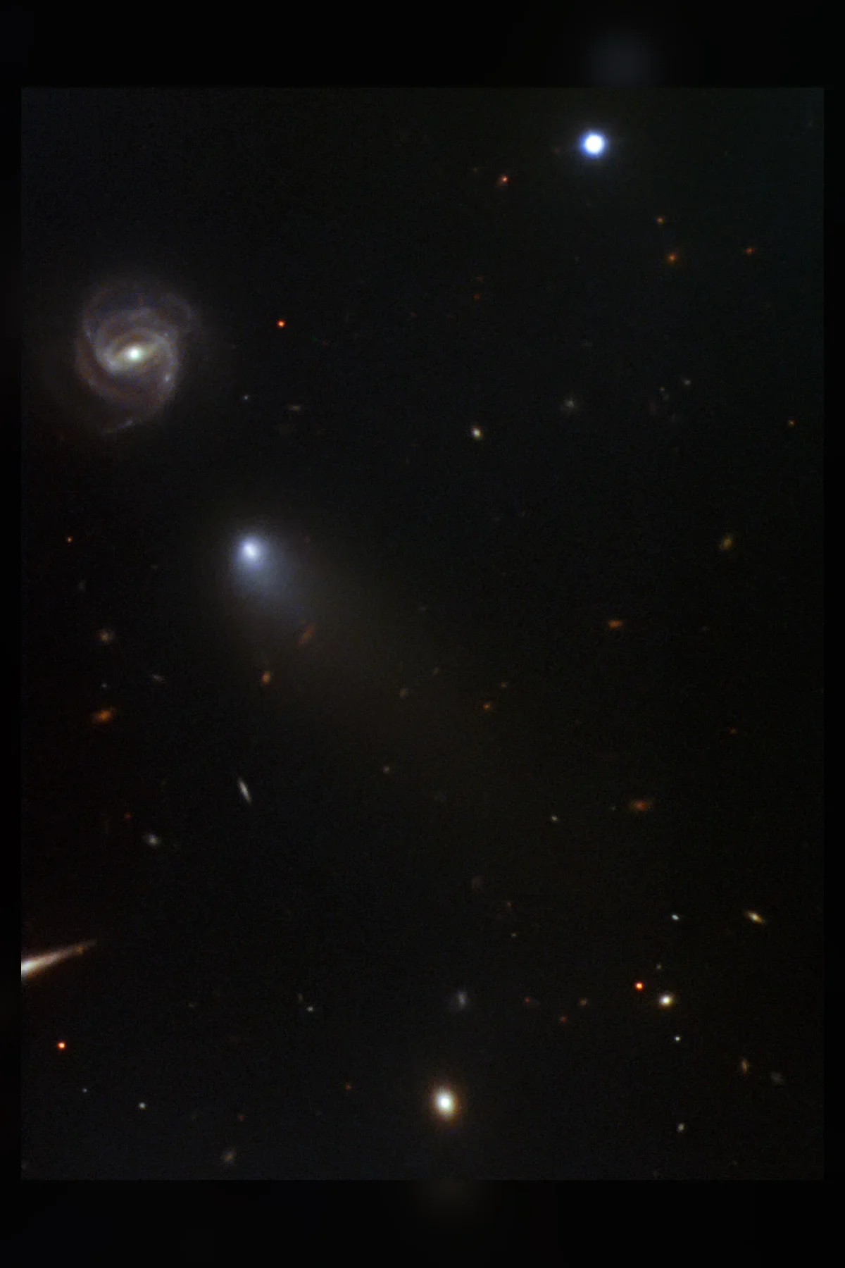 A comet with a bright blue-white head and a faint tail against a dark star field, with a small galaxy nearby