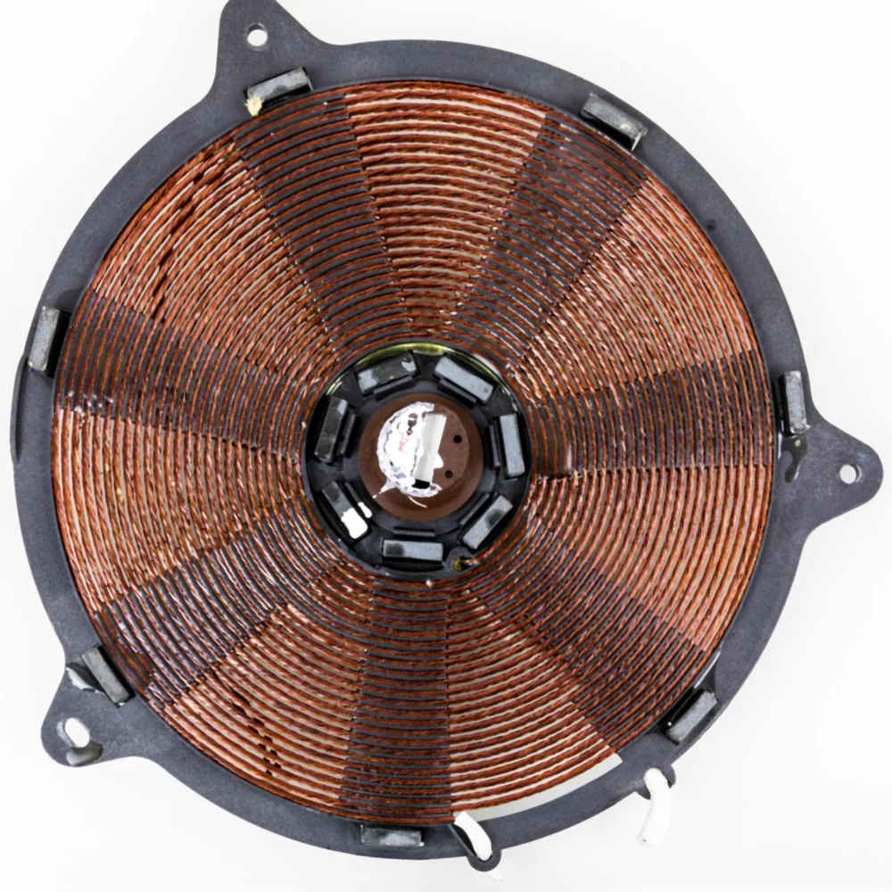 A flat spiral of twisted copper wire in a black frame, from an induction hob.