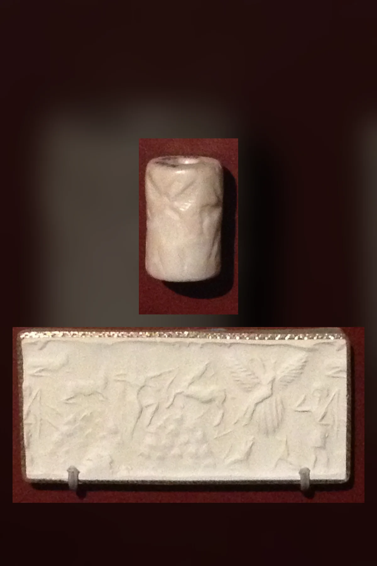 A small pale stone cylinder seal above a long white strip of its rolling, showing a large bird in flight with a figure on its back among animals and people.