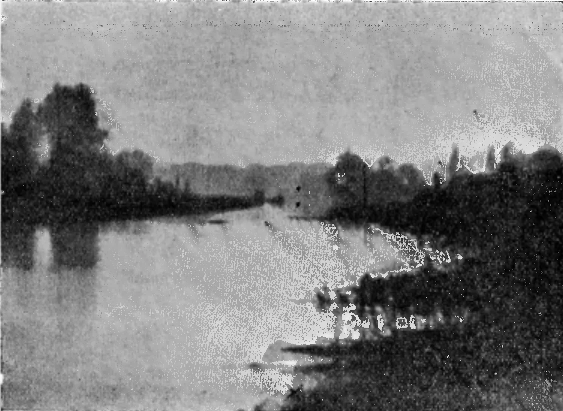 A grainy, misty photograph along a wide stretch of water, with dark trees on the left, a low bank on the right and a faint pale patch far off where the water meets the land.