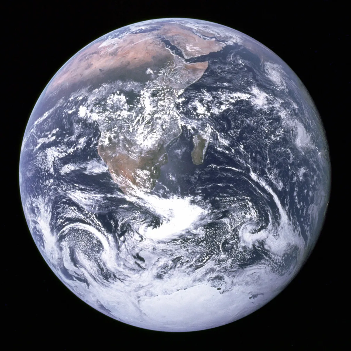 A full Earth against black, with Africa and Arabia in the centre, white Antarctica at the bottom and swirling cloud over blue ocean.
