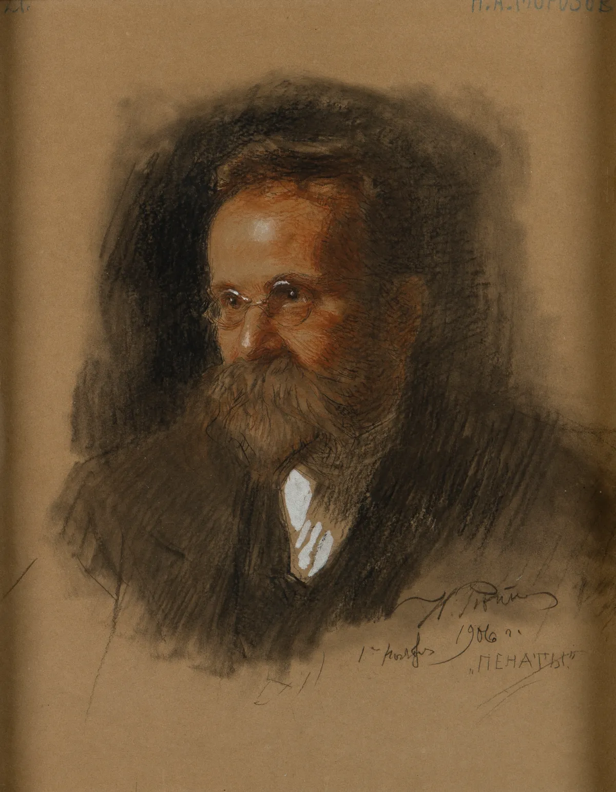 A portrait drawing on brown paper of a bearded man in round glasses, looking to the side, signed by the artist.