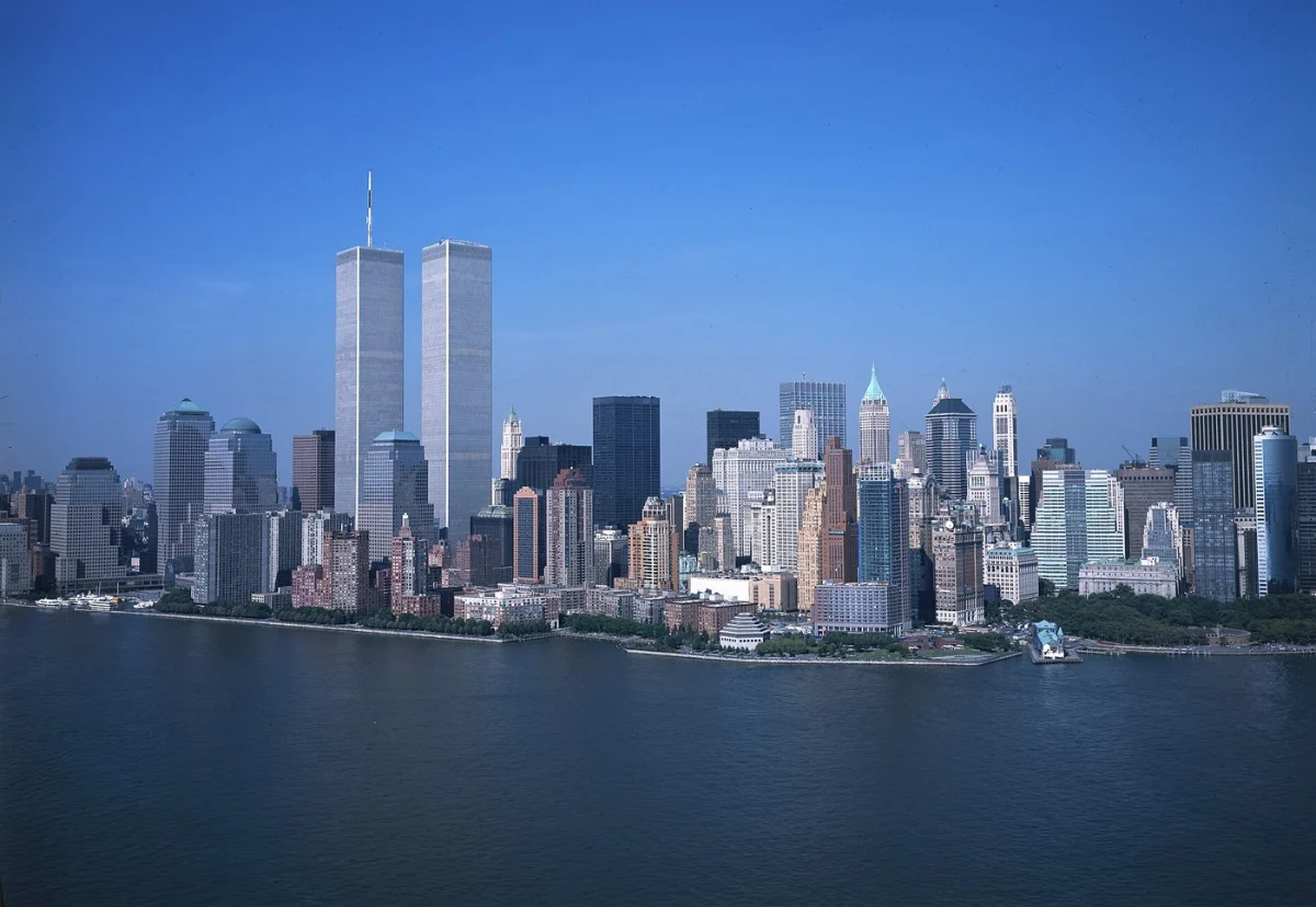 Two tall towers above lower Manhattan, seen across the water.