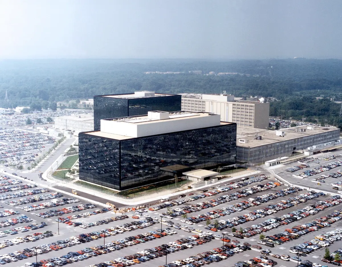 An aerial view of dark glass office blocks surrounded by a vast car park.