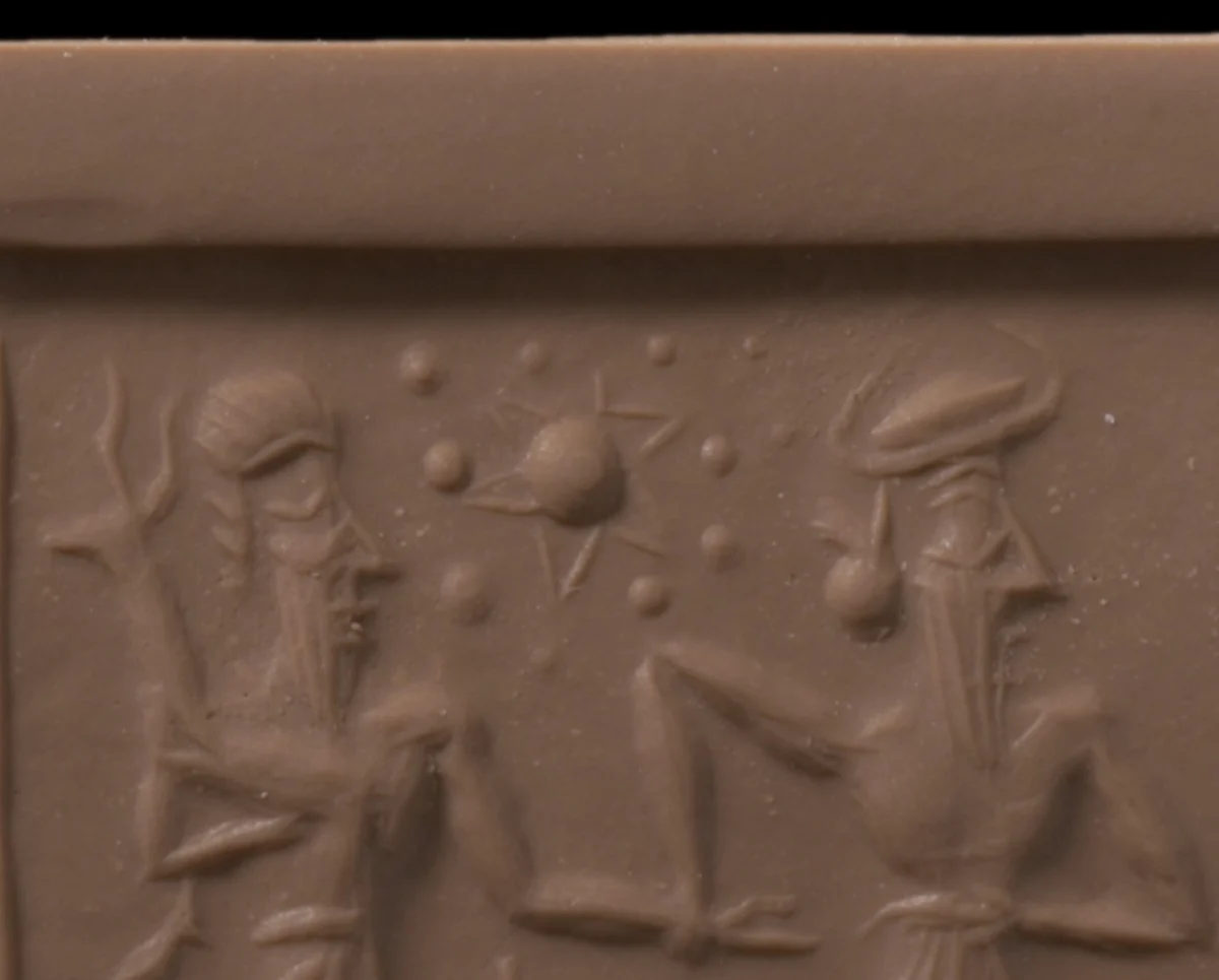 Close view of the clay rolling: between two bearded figures, a raised ball with thin rays behind it, ringed by smaller raised balls of uneven size.