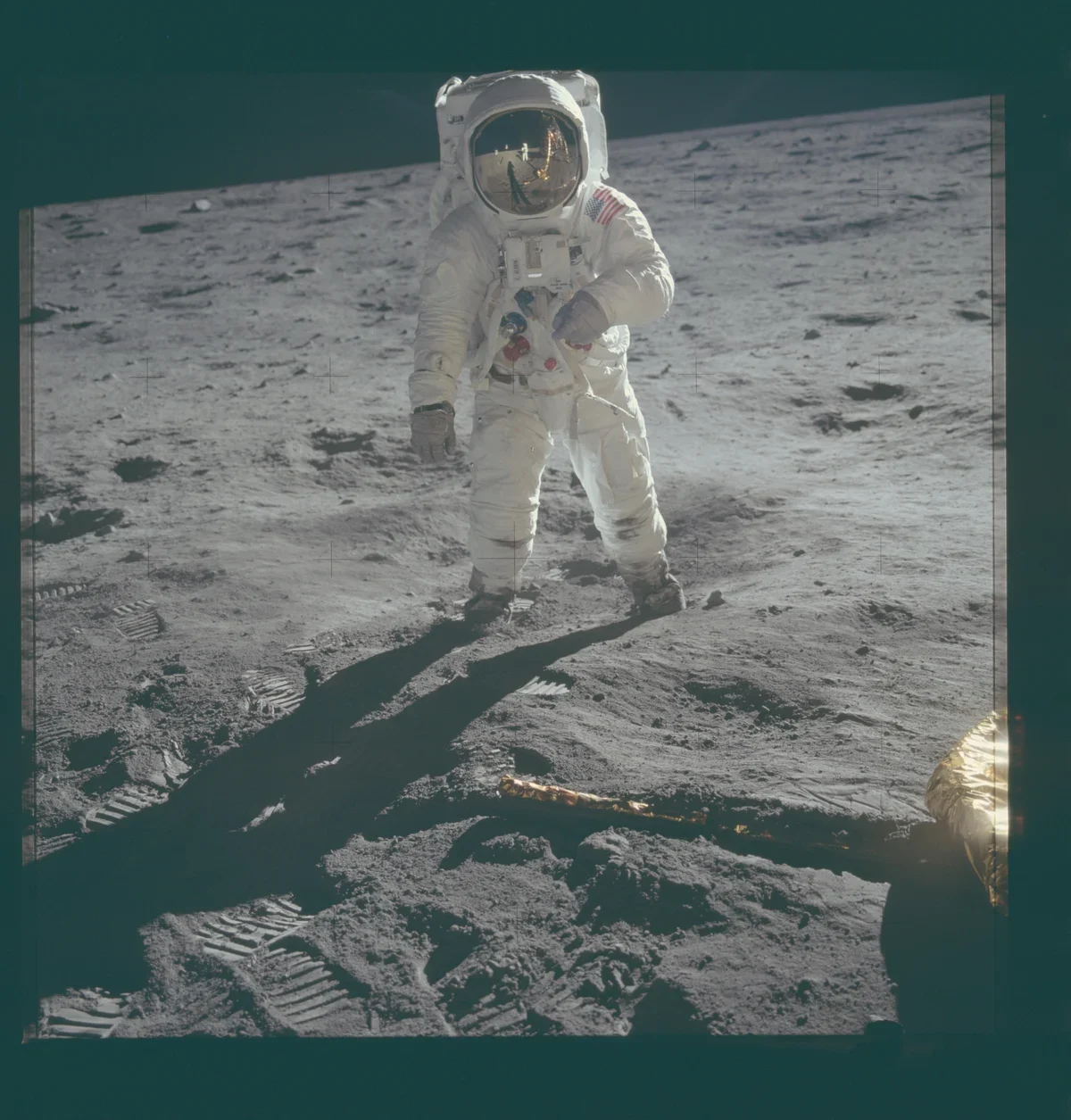Buzz Aldrin on the sunlit lunar surface beneath black sky, NASA frame AS11-40-5903.