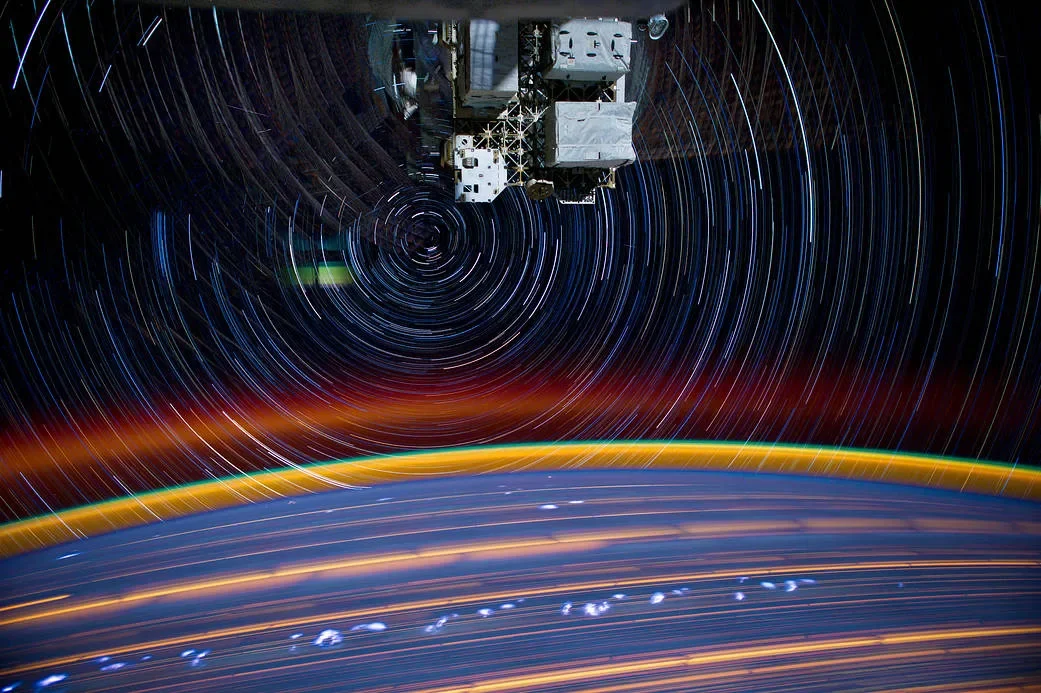 Curved star trails above Earth in a composite of multiple 30-second exposures.