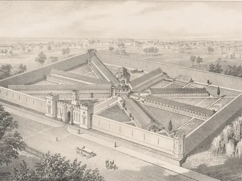A lithograph bird's-eye view of a walled prison with corner towers and a castle-like gate, its long cell blocks radiating like spokes from a central hub.